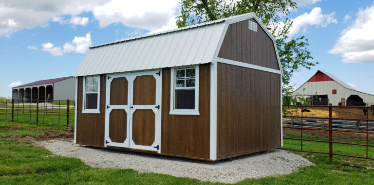 A brown, wide outdoor shed with white trim and metal roofing
